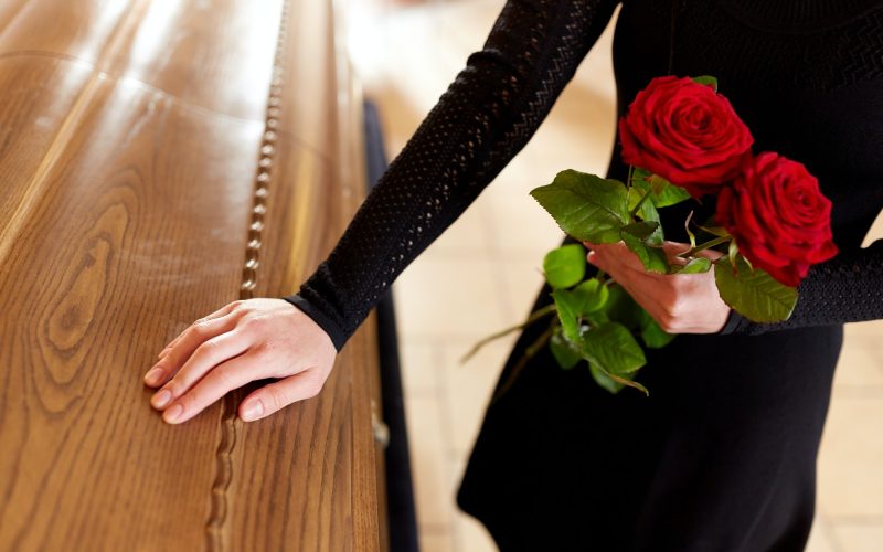 woman-with-red-roses-and-coffin-at-funeral-1.jpg